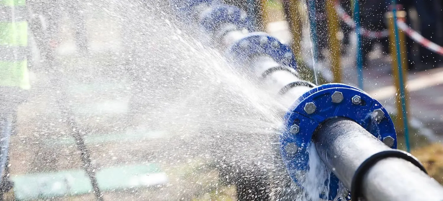 A severe high-pressure pipe leak spraying water outdoors, requiring the urgent 24/7 emergency plumbing Sapulpa home and business owners rely on