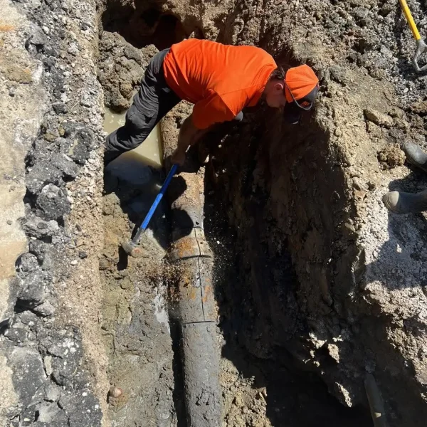Wooten Plumbing team member in trench working on commercial plumbing service